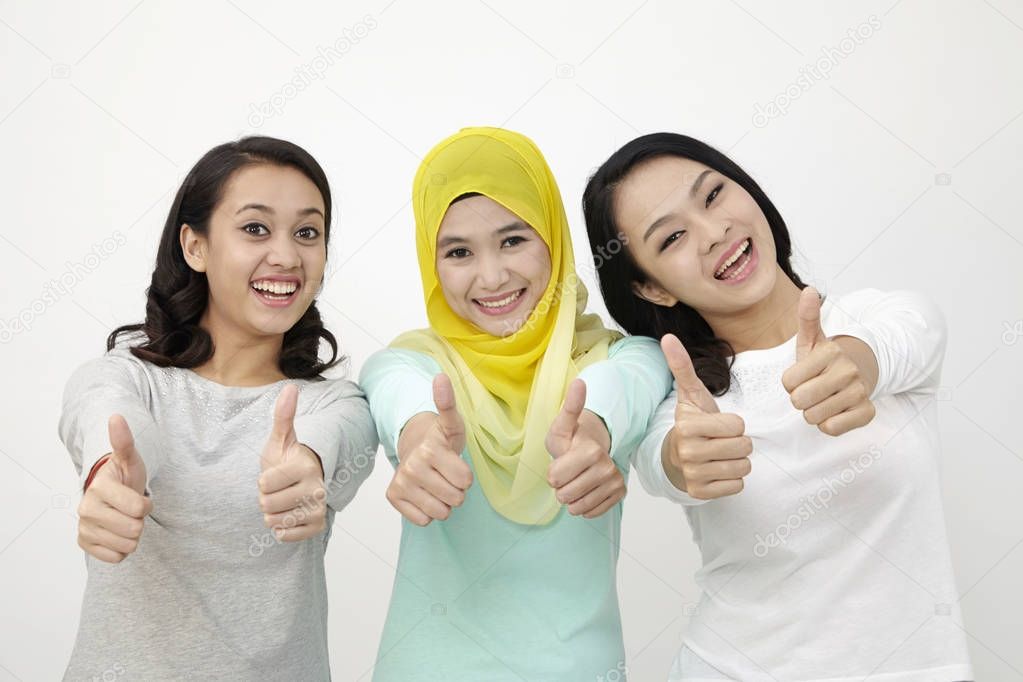 three Malaysian women raising thumbs up