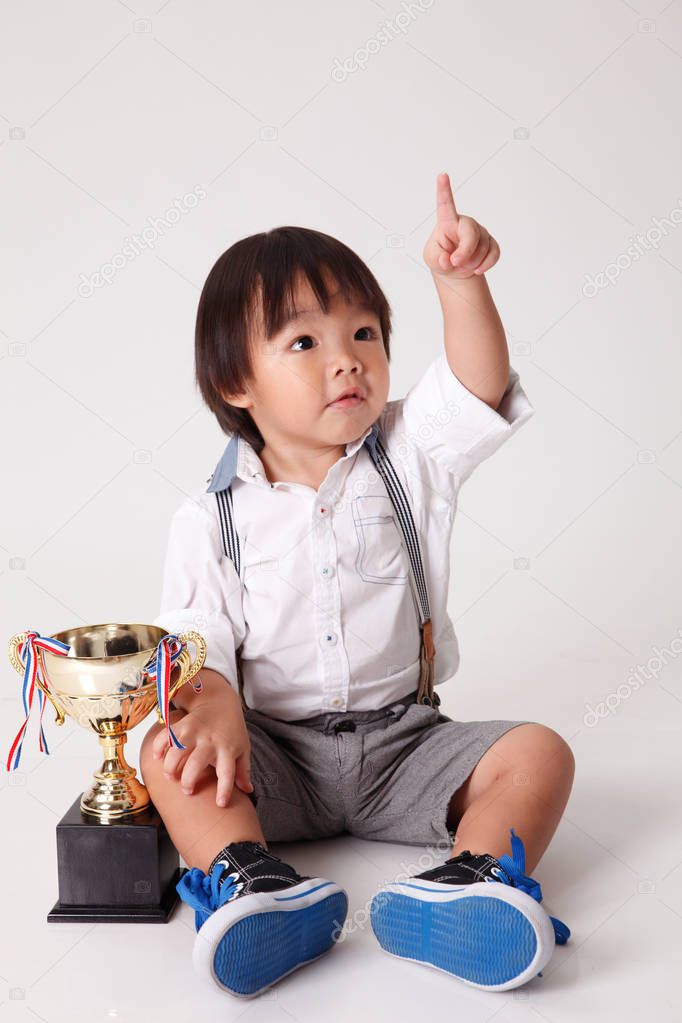 chinese boy with gold trophy