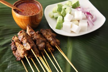 Malezya gıda satay salatalık, soğan ve ketupat ile muz yaprak üzerinde