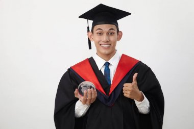 malay genç mezun öğrenci bir küre tutan 