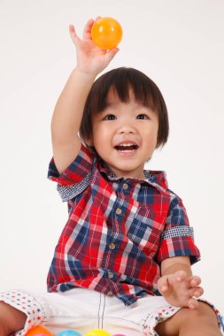 Çinli çocuk oyuncakları ile oynarken oturuyor