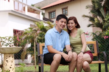 Çinli çift bankta oturan