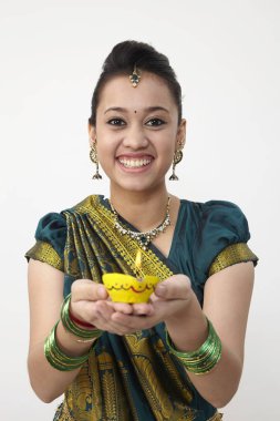 Sarı kandil tutan saree giyen kadın