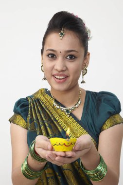 Sarı kandil tutan saree giyen kadın