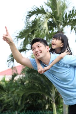 Kızı arka taşıyan baba