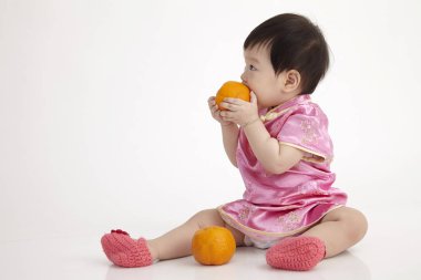 Çinli bebek bir mandarin portakal holding cheomgsam giyiyor