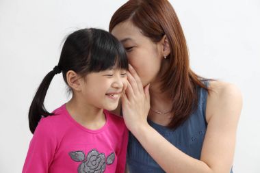 mother sharing secret by whispering to the daughter clipart