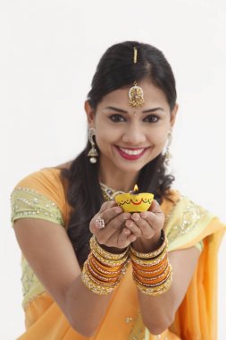 Göz alıcı geleneksel giyim kandil tutan Hintli kadın