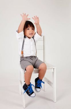 Çinli çocuk elini yetiştirme büyük taburede oturan