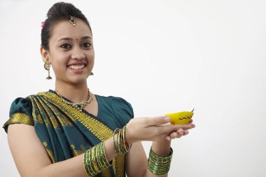 Sarı kandil tutan saree giyen kadın