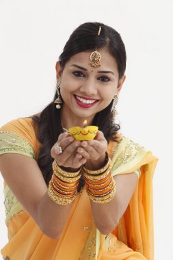 Göz alıcı geleneksel giyim kandil tutan Hintli kadın