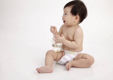 Studio poz holding şişe oturan Çinli bebek kız 