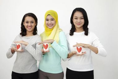 Üç multi ırksal Malezya holding Kupası kameraya bakarak aşk