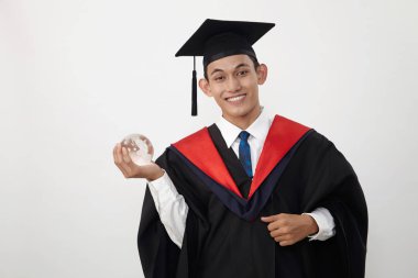 malay genç mezun öğrenci bir küre tutan 