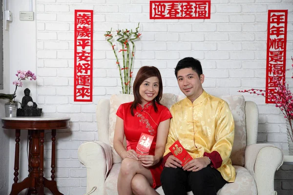 chinese couple sitting on the sofa with chinese new year decoration greeting