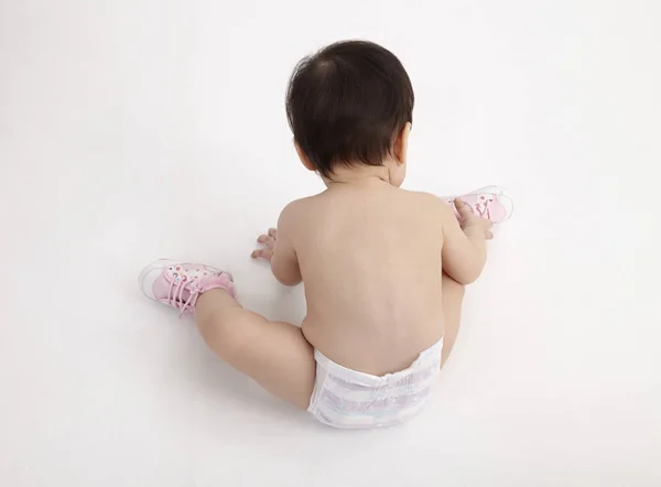 Chinese Baby Girl Picking Shoe — стоковое фото