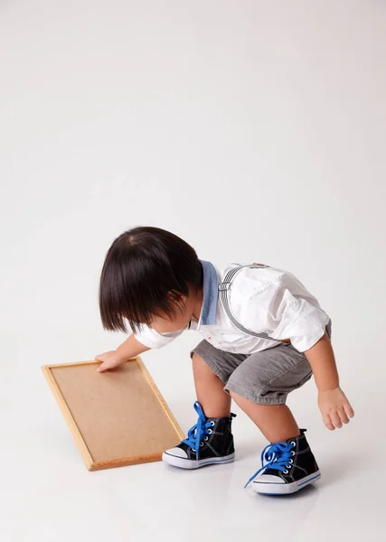 Studio Shot Van Een Chinese Jongen Holding Krijt Bestuur — Stockfoto