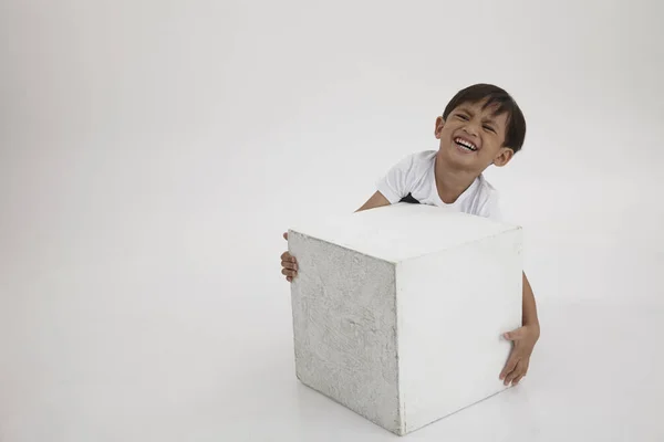 boy try lift a heavy white box