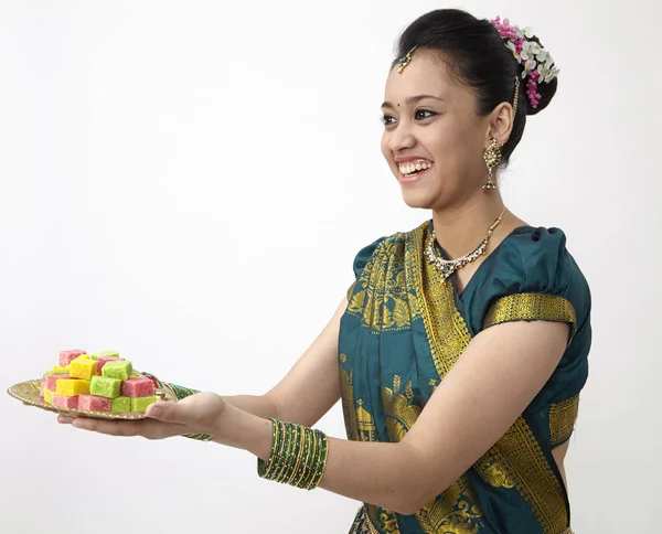 お菓子のトレイを保持側ビュー陽気なインド女性 — ストック写真
