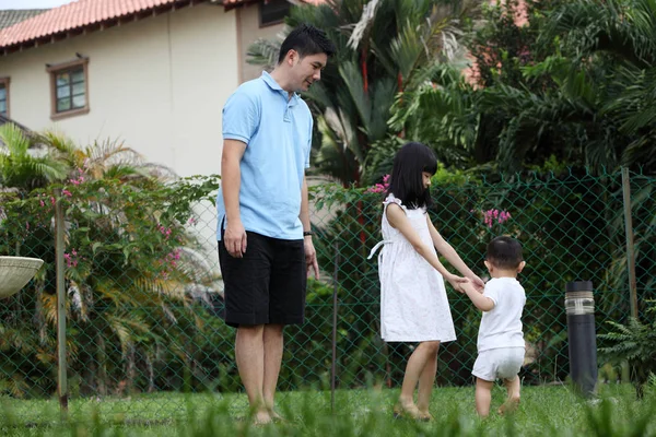 家庭在他们的庭院引导婴孩步行 — 图库照片