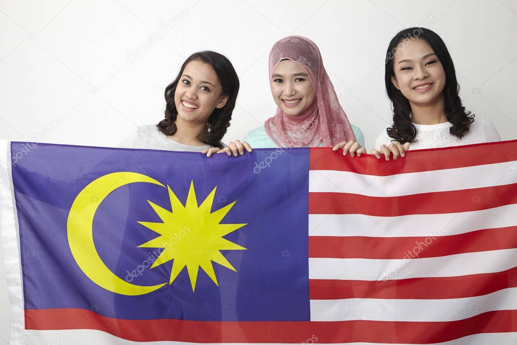 malaysian girls  holding big flag posing in studio 