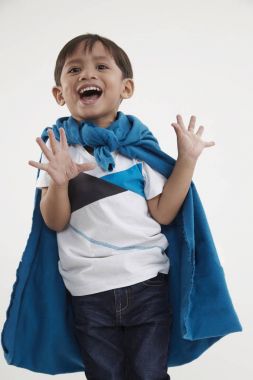 malay çocuk mavi pelerin gibi bir süper kahraman gibi giyiyor