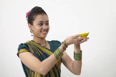 Sarı kandil tutan saree giyen kadın