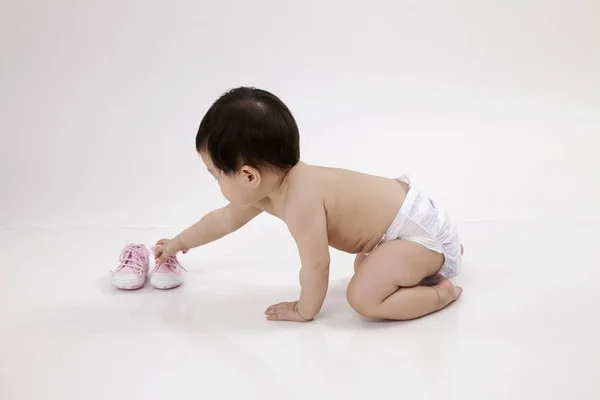 Chinois Bébé Fille Ramasser Une Chaussure — Photo