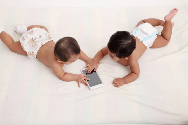 两个婴儿在智能手机上打架 — 图库照片