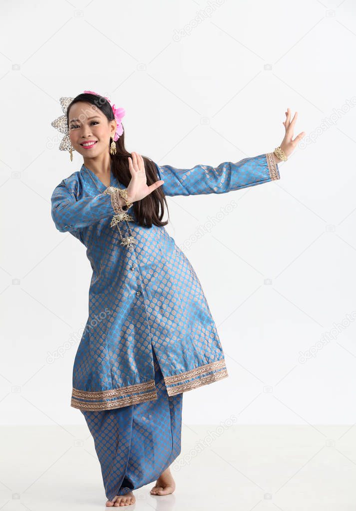 malay woman in traditional costume dancing in studio