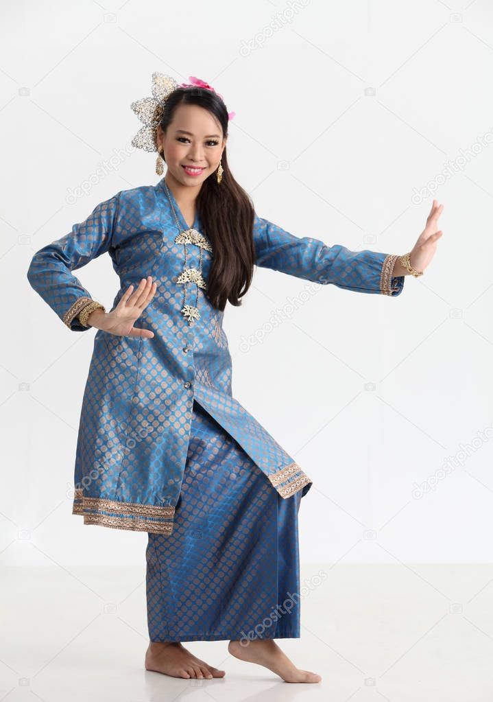 malay woman in traditional costume dancing in studio