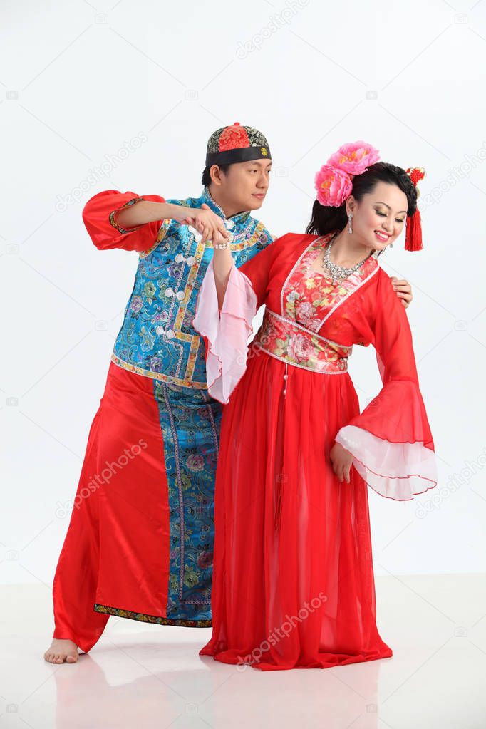 Chinese couple with traditional costumes posing in studio 