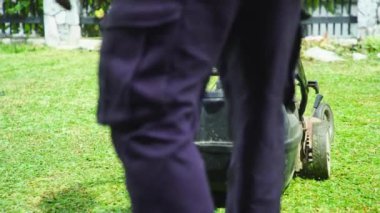 Çim biçme makinesi olan işçi