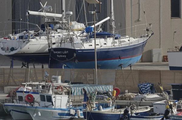 Italia, Sicilia, Mar Mediterráneo, Marina di Ragusa; 15 de octubre de 2016, barcos de pesca de madera y yates de lujo en tierra en un astillero en el puerto - EDITORIAL — Foto de Stock