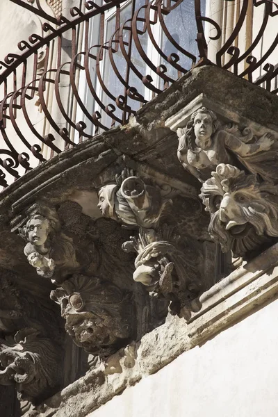 Itálie, Sicílie, ragusa ibla, barokní fasáda cosentini paláce (památka unesco), okrasné sochy pod balkonem — Stock fotografie