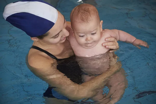 Italien, ung mamma och hennes nyfödda gossebarn i en pool — Stockfoto