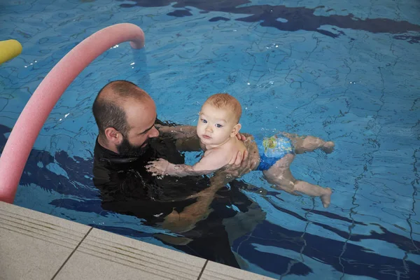 Italien, simning tränare undervisning ett nyfött gossebarn i en pool — Stockfoto