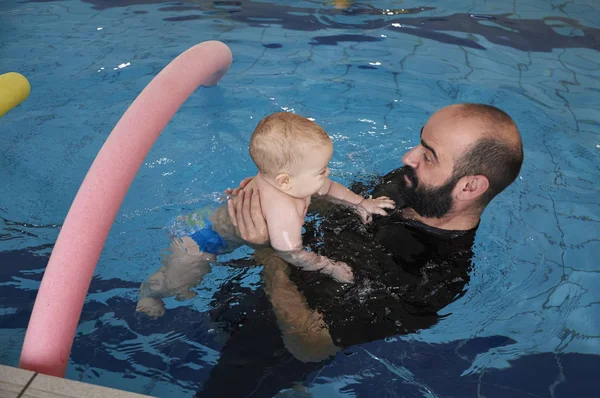 Italien, simning tränare undervisning ett nyfött gossebarn i en pool — Stockfoto