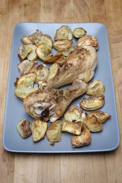 Grillade kycklingklubbor med potatis på en maträtt — Stockfoto