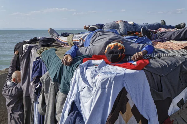 Italien, Mittelmeer, Sizilien, scoglitti (Provinz Ragusa); 8. März 2011, afrikanische Einwanderer schlafen auf einem Betonklotz im Hafen, während ihre Kleidung unter der Sonne trocknet - Leitartikel — Stockfoto