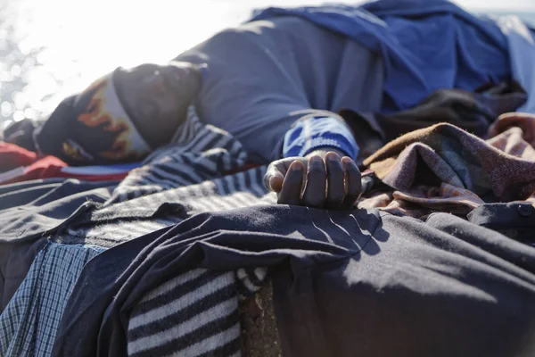 İtalya, Akdeniz, Sicilya, Scoglitti (Ragusa eyaletinde); 8 Mart 2011, Afrika göçmen giysilerini güneşin altında - editoryal kurutma süre bir beton blok Port, Yataklı vagon