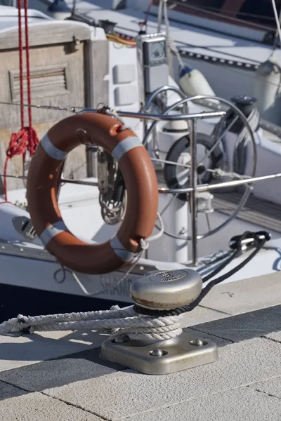 Italy, Sicily, Marina di Ragusa; 19 January 2017, a bollard, nautical ropes and a sailing boat in the port - EDITORIAL — Stock Photo, Image