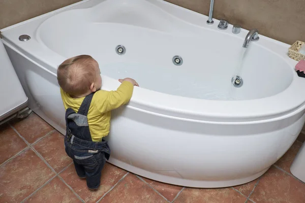 Infant male in a bathroom close to a bath tub — Stock Photo, Image