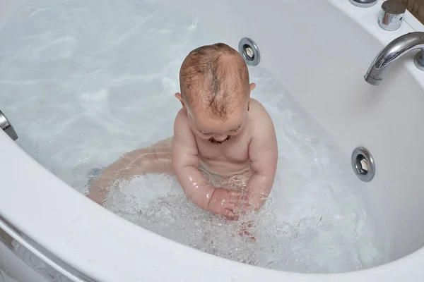 Portrait of an infant male playing with water in a bath tub — Stock Photo, Image