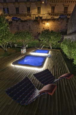 İtalya, Sicilya, Modica (Ragusa eyaletinde), jakuziler bir bahçe geceleri