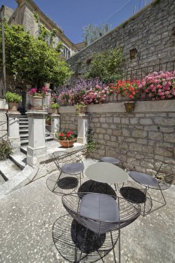 İtalya, Sicilya, Modica (Ragusa eyaletinde), çiçekli bir teras sandalyeler