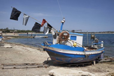 İtalya, Sicilya, Akdeniz, Sampieri (Ragusa eyaletinde); küçük ahşap balıkçı teknesi karaya