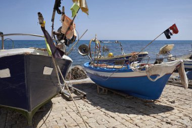 İtalya, Sicilya, Akdeniz, Sampieri (Ragusa eyaletinde); 5 Haziran 2017, Balıkçılık Tekne ve karaya - editoryal halka için ağlar