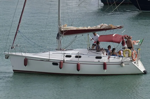意大利的西西里岛，地中海，玛丽娜迪拉古;2017 年 7 月 23 日，港口-社论坐一艘帆船上的人 — 图库照片