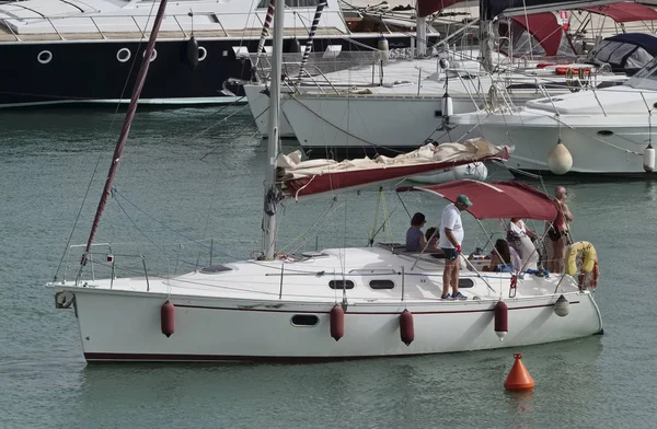 Italia, Sicilia, Mar Mediterraneo, Marina di Ragusa; 23 luglio 2017, persone in barca a vela nel porto - EDITORIALE — Foto Stock